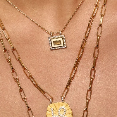 Colares dourados com pendentes LOVE e quadrado com pedras na pele