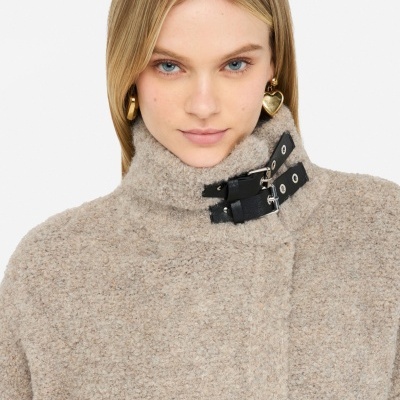 Casaco bege felpudo com gola alta e fivelas pretas, uso feminino.