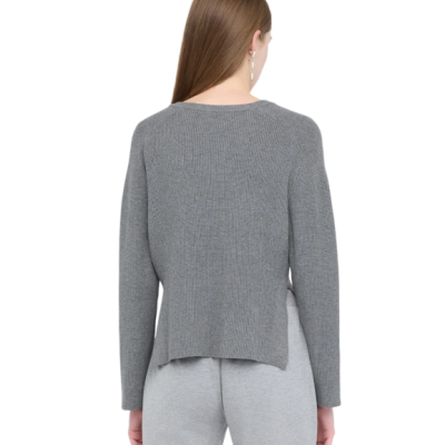 Mulher de costas com camisola cinzenta e calças cinzentas