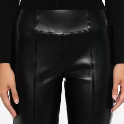 Calças pretas justas de pele sintética com costuras frontais e camisola preta de malha