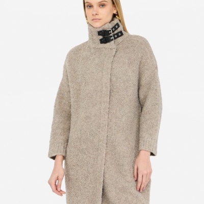 Casaco bege de malha com gola alta e fivelas pretas no pescoço