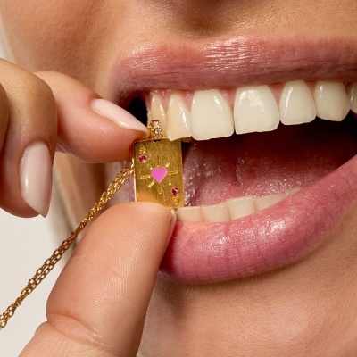 Colar dourado com pendente retangular com coração rosa e cristais