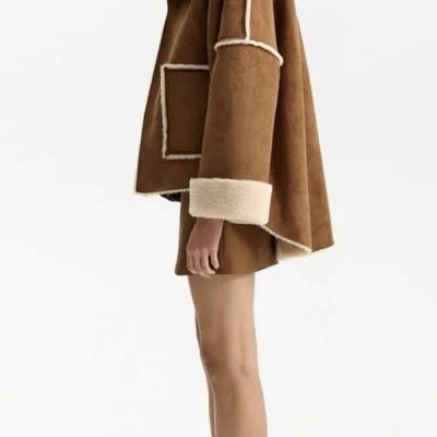 Modelo feminino com casaco castanho de pelo e botas castanhas de salto