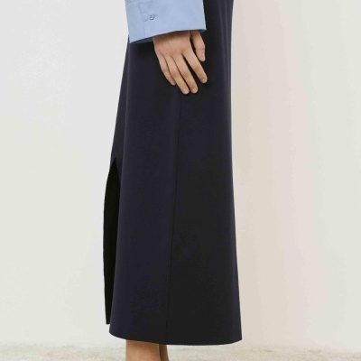 Calças femininas largas azul escuro com fendas usadas com camisa azul clara e sapatilhas pretas