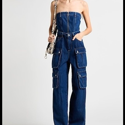 Macacão de ganga azul escuro com bolsos e fecho frontal, usado por mulher