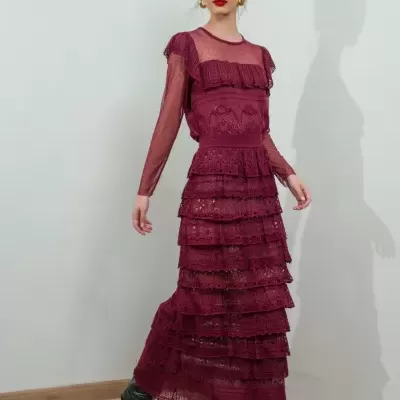 Vestido longo bordô com rendas e transparências usado por mulher