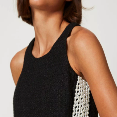 Top preto com textura e franjas de pérolas brancas na lateral