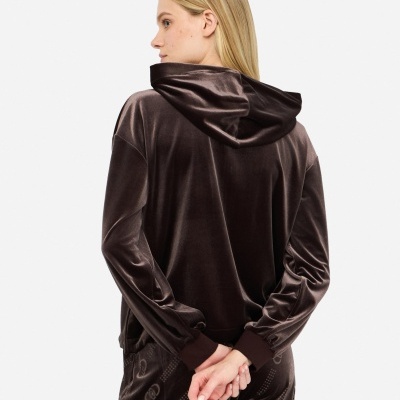 Casaco com capuz de veludo castanho escuro e calças castanhas com padrão de logótipos, vista de costas