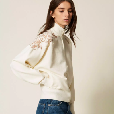 Casaco branco com renda floral nos ombros e calças de ganga azul