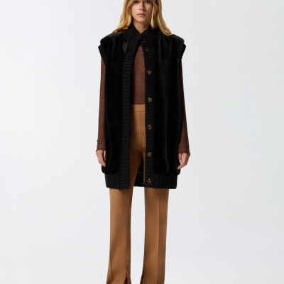 Mulher com roupa castanha e preta em fundo branco