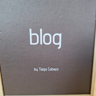 Livro com capa dura marrom com título 'blog' em branco dentro de caixa de madeira clara
