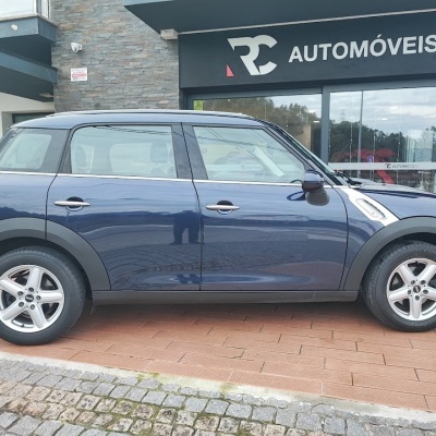 Carro Mini Countryman azul escuro estacionado em frente à loja RC AUTOMÓVEIS.