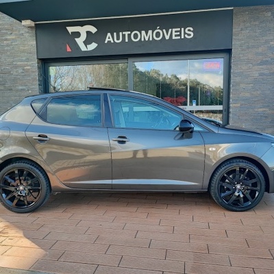 Carro cinzento metálico com jantes pretas em frente a loja RC AUTOMÓVEIS