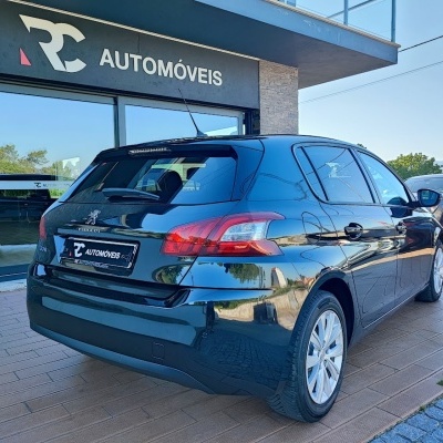 Carro preto estacionado em frente à loja RC Automóveis