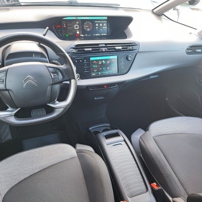 Interior de carro Citroën, volante, painel digital, bancos cinza e preto