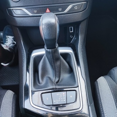 Alavanca de cambio manual preta em interior de carro com painel preto e detalhes cromados