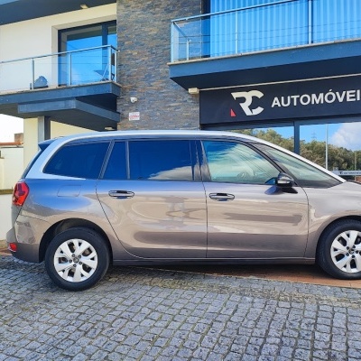 Automóvel cinzento metálico estacionado em frente a loja RC Automóveis