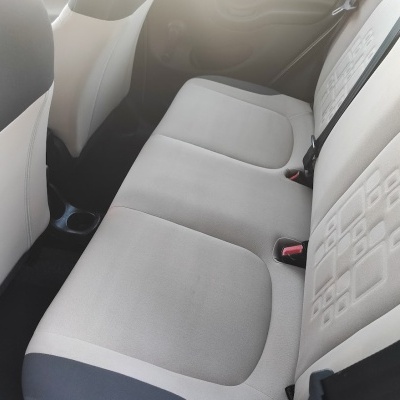 Banco traseiro de carro em tecido cinza claro com padrão em quadrados e cintos de segurança