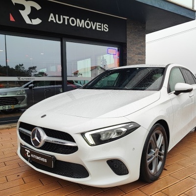 Carro Mercedes-Benz branco à frente de loja RC AUTOMÓVEIS com sinal OPEN