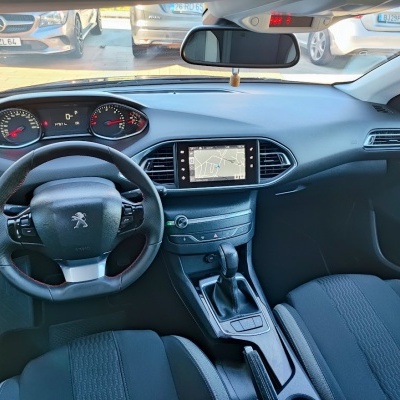 Interior do carro Peugeot com volante em couro preto e ecrã tátil no painel central