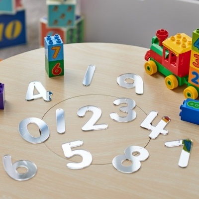 Brinquedos coloridos de blocos com números e números metálicos numa mesa redonda de madeira