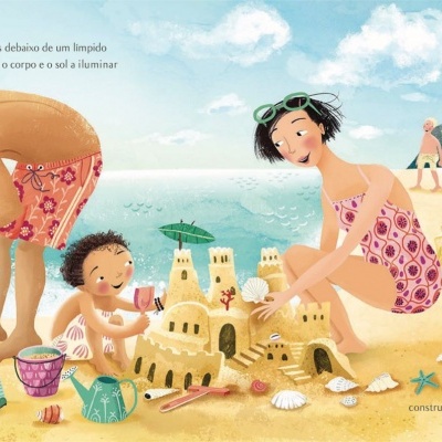 Família a construir castelo de areia na praia com farol ao fundo