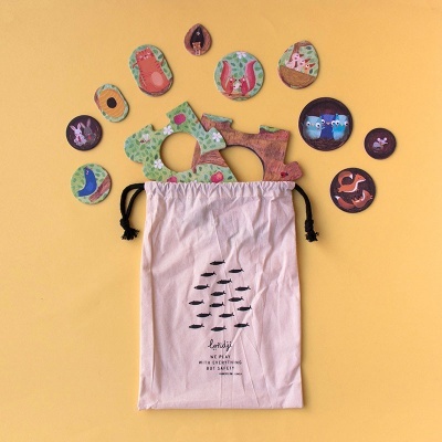 saco de tecido com cordão e puzzles de madeira com desenhos de animais e plantas