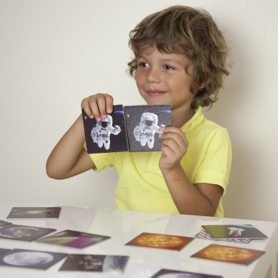 Criança a segurar cartas com imagens espaciais