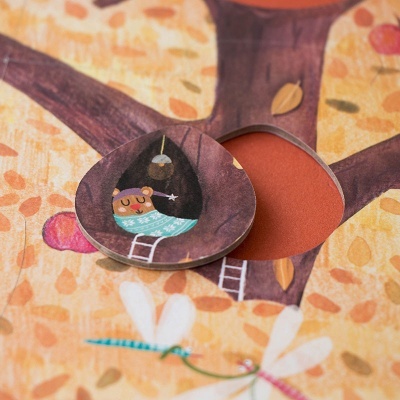 Livro infantil com ilustração de gato a dormir numa casa na árvore e folhas de outono