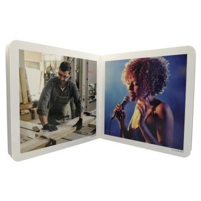 Livro aberto com fotos de homem a trabalhar madeira e mulher a cantar num palco