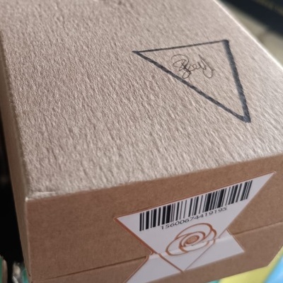 Caixa de cartão castanha com código de barras e etiquetas triangulares