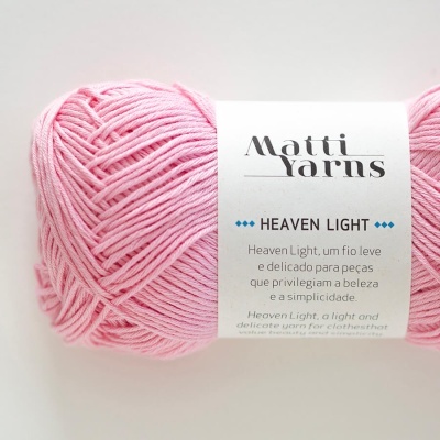 Novelo de lã rosa claro com etiqueta Matti Yarns Heaven Light em fundo branco