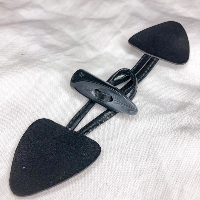 Fecho toggler preto sobre tecido branco