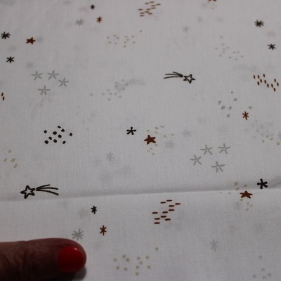 tecido branco com estrelas e pontos coloridos e mão feminina
