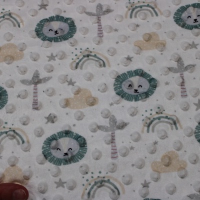 Tecido branco com padrão colorido de leões, camelos, palmeiras e arco-íris com textura bolha