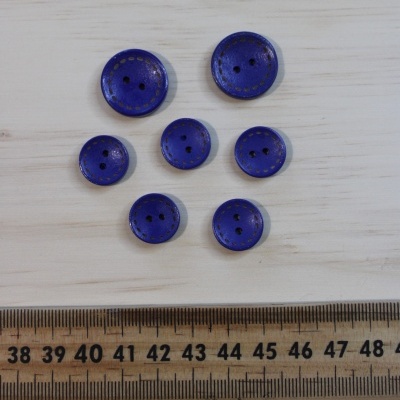 Sete botões azuis com detalhes dourados e régua de madeira