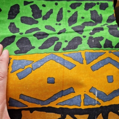 Tecido colorido geométrico e estampado segurado por mão