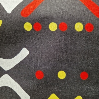 Tecido cinza com padrão geométrico colorido em branco, vermelho, amarelo e laranja