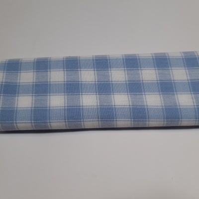 Guardanapo tecido azul e branco com padrão xadrez sobre superfície branca