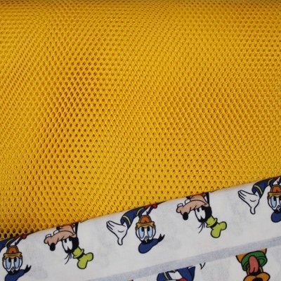 Tecido amarelo em malha e tecido branco com estampa do Pato Donald.