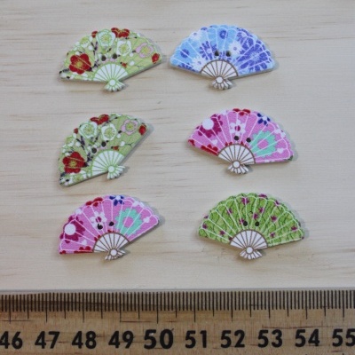 Seis botões em forma de leque com padrões florais e régua em cm abaixo