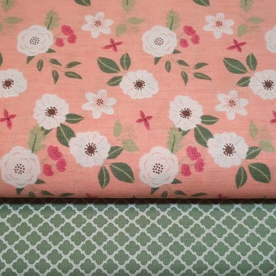 Tecidos rosa com flores brancas e verdes, e tecido verde com padrão branco geométrico