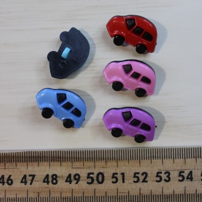 Botões em forma de carros coloridos sobre madeira com régua