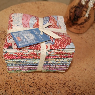 Conjunto de tecidos dobrados coloridos com etiqueta azul sobre superfície castanha texturada