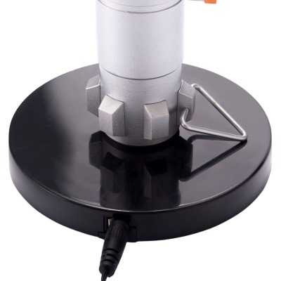 Base redonda preta brilhante com equipamento metálico cinzento e cabo preto