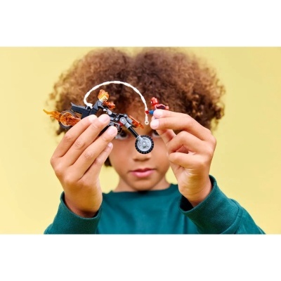 Criança a segurar brinquedo de construção com mota preta e figuras de ação