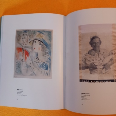 Livro aberto mostrando ilustração colorida e fotografia preto e branco com texto Volksbank