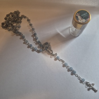 Terço transparente com crucifixo prateado e frasco com tampa dourada