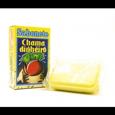 Sabonete amarelo com caixa de papel amarelo e azul com texto 'Sabonete Chama dinheiro' e ilustração
