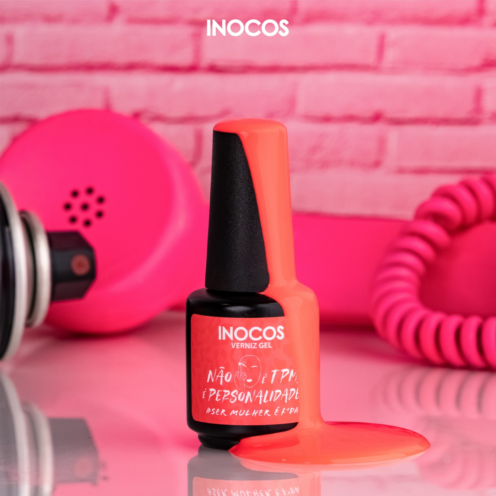 Verniz Gel Inocos – 318 - Não é TPM é Personalidade Frasco de verniz gel vermelho INOCOS com tinta derramada e telefone rosa vintage ao fundo